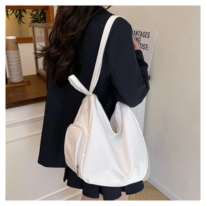 Close-up of a white tote bag featuring a side zipper pocket and soft pleated texture
