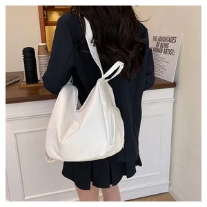 Close-up of a white leather hobo backpack with functional side zippers and wide straps