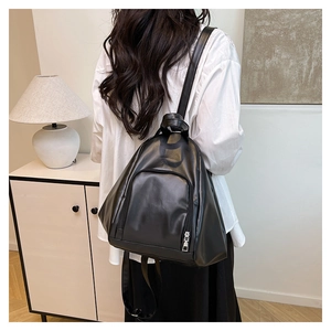 Detail of a black pleated leather backpack with teardrop design and slim straps