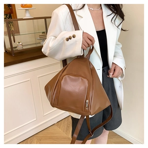 Brown leather convertible backpack showing refined texture and geometric design on a model