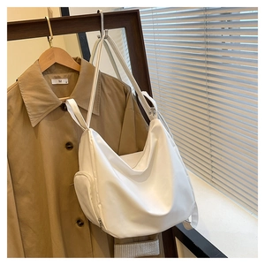 Close-up of white versatile canvas shoulder bag showing the side zipper pocket detail