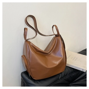Detail view of the brown large capacity tote bag with smooth faux leather texture