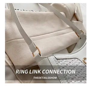 Detail der weißen Schultertasche mit Flechtstruktur und goldener Metallring-Verbindung