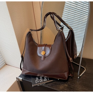 Détail du sac cabas en similicuir marron foncé avec finition mate et logo en métal