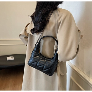 Détail du sac croissant matelassé noir avec bandoulière chaîne dorée et poignée