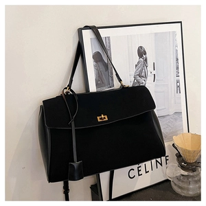 Detail of black suede tote bag with golden twist lock and matte leather side panel