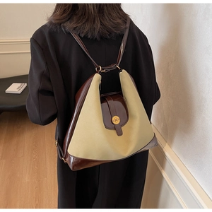 Détail d'un sac à dos en toile beige et similicuir marron avec boucle métallique en N