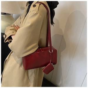 Detail of red faux leather shoulder bag with matching mini pouch and silver zipper