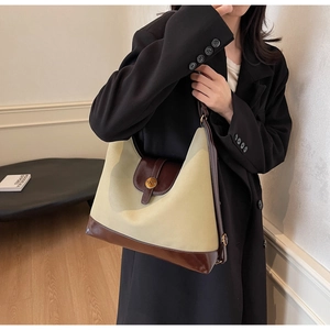 Détail du sac fourre-tout rétro en toile et cuir marron avec boucle logo N en métal