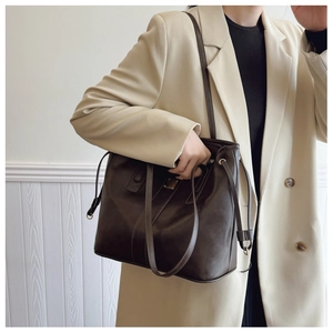Deep coffee brown tote bag detail with adjustable strap on a minimalist office blazer outfit