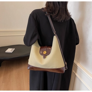 Détail de la boucle ronde en métal avec logo N sur un sac cabas vintage en cuir
