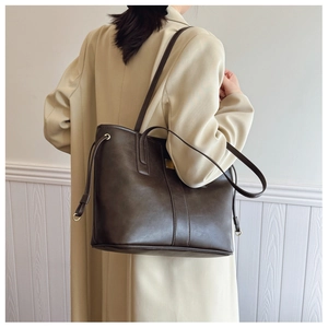 Detail of dark brown tote bag with vintage texture and golden hardware decoration