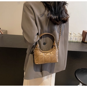 Vue arrière du sac matelassé marron avec chaîne sur un mannequin en blazer gris