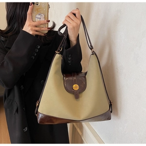 Détail d'un sac cabas rétro en tissu beige avec garniture marron brillant et boucle dorée