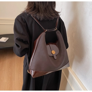 Détail d'un sac à dos patchwork marron avec bretelles doubles et fermoir en métal doré