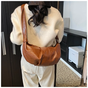 Rear view of brown retro pleated croissant bag showing the unique knot detail on strap