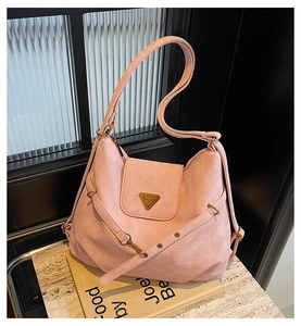 Detail of light pink suede hobo bag with gold triangle logo and ruched strap details
