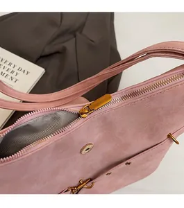 Detail of pink matte shoulder bag featuring smooth metal zipper and magnetic closure