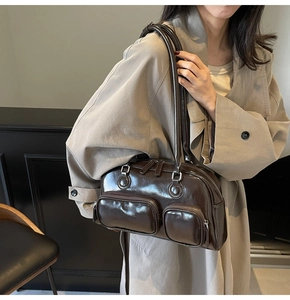 Detail of a dark chocolate glossy bowling bag with multiple functional zip pockets