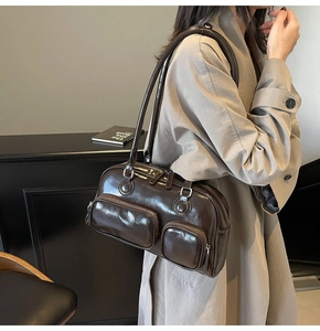 Detailed view of the dark brown oil-wax leather shoulder bag with multi-zipper pockets