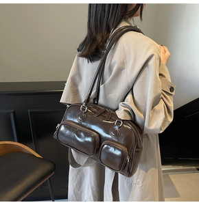 Detail view of deep brown glossy bowling bag with multiple front zipper pockets