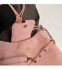 Detail of pink matte handbag showing magnetic snap closure and vintage bronze hardware