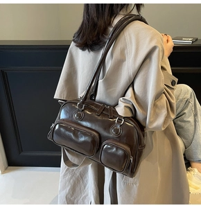 Detail of glossy dark brown leather bowling bag with vintage multi-pocket design