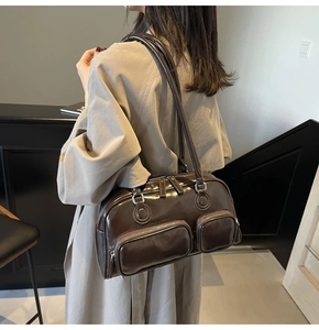 Detail of dark brown wax leather shoulder bag with multiple front zipper pockets