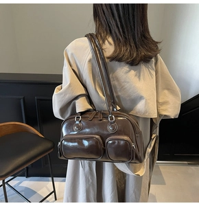 Close-up of vintage dark brown waxed leather shoulder bag with functional front zip pockets