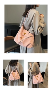 Detail of pink multi-way bag showing matte texture and golden triangle metal buckle