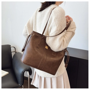 Brown retro leather tote bag with gold hardware detail and side drawstring design