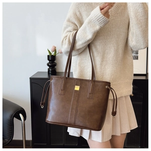 Close-up of vintage dark brown tote bag with premium metal buckle and textured leather detail