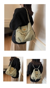 Detail of green suede tote bag showing the triangular metal logo and adjustable strap