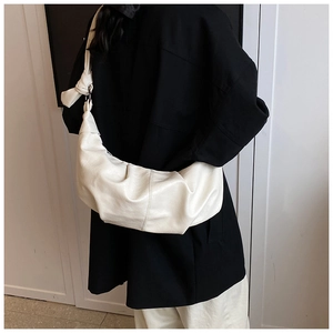 Detail of soft cream hobo bag showing the unique knot design on the shoulder strap
