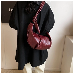 Detailed view of the retro burgundy pleated croissant bag with metal ring knot strap