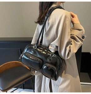 Detail of vintage black bowling shoulder bag featuring double front zipper pockets and leather finish