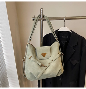 Detail of mint green suede hobo bag with triangle logo and metallic buckle closure