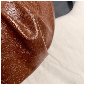 Close-up of caramel brown pleated faux leather texture with soft natural grain