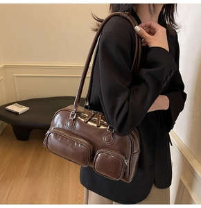Detail of dark brown polished leather bowling bag with functional 3D zipper pockets