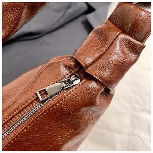 Detail of soft brown leather texture with pebble grain and smooth metal zipper closure