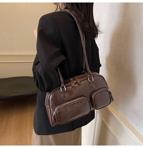 Detail view of vintage dark brown bowling bag with double front zippers on shoulder