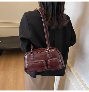 Close-up of vintage burgundy glossy leather shoulder bag with multi-pocket design detail