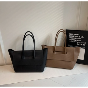 Close-up of high-quality lychee grain leather texture on black and khaki tote bags