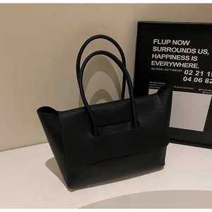 Close-up of black lychee texture leather tote bag featuring a minimalist flap cover