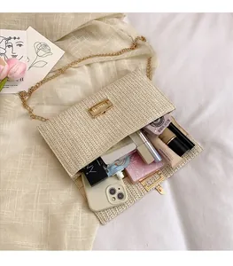 Detail view of woven straw envelope bag showing spacious interior with cosmetic items