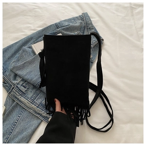 Bolso bandolera minimalista de ante negro con detalles de flecos y correa delgada