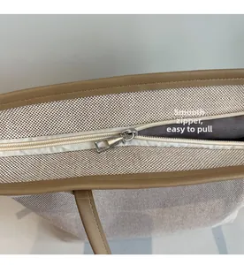 Close-up of smooth metal zipper and canvas texture on the large contrast tote bag