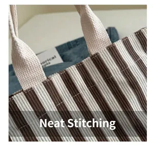 Close-up showing precision double-stitch sewing on a striped canvas tote bag detail