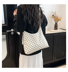 Borsa tote in tela a pois indossata dal modello che mostra la forma morbida e la capienza
