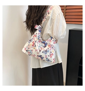 Dettaglio della borsa tote in tela con stampe di farfalle colorate e un elegante fiocco sulla spalla